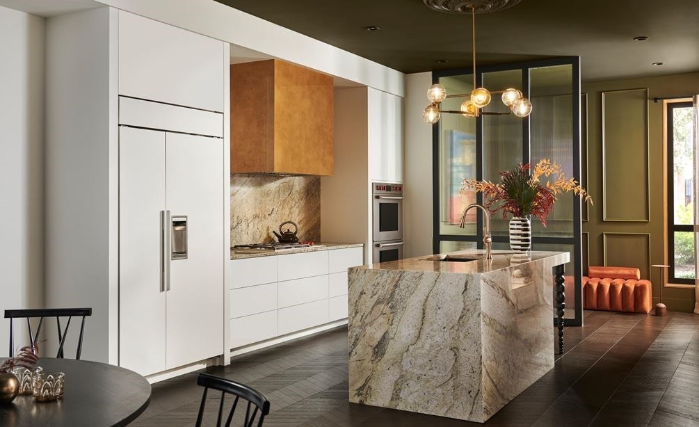 Panel Ready Sub-Zero 42 inch Classic Side-by-Side Refrigerator blends perfectly into white kitchen cabinetry in this modern and bold custom kitchen design featuring granite kitchen isalnd and matching backsplash