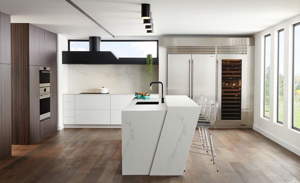 Stainless Steel Sub-Zero 48 Inch Classic French Door Refrigerator Freezer blends expertly in this sleek modern European style kitchen design featuring large white marble kitchen island.