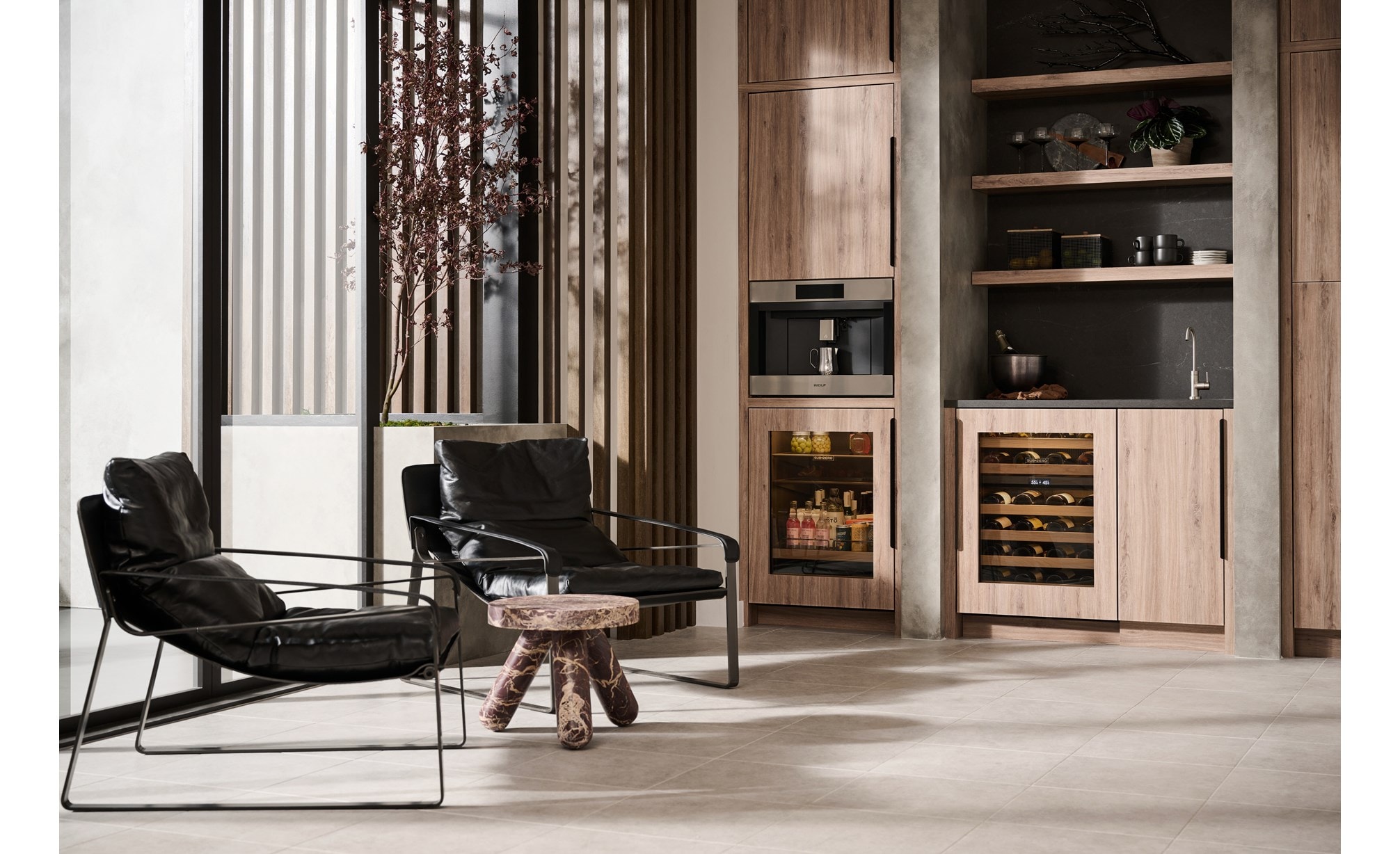 Wolf 24 Inch E Series Transitional Coffee System featured in a luxury coffee bar area with leather swing back chairs