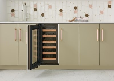 Interior view of Sub-Zero 15" Designer Undercounter Wine Storage - Panel Ready (DEU1550W) with six wood bordered shelves shown in a row of tan custom cabinets