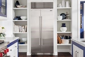 Sub-Zero Classic Glass Door Refrigerator framed between two exposed kitchen cabinets in a modern white kitchen design 