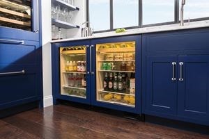 Paired Sub-Zero Undercounter Beverage Center featuring glass doors, custom panels and chrome handles