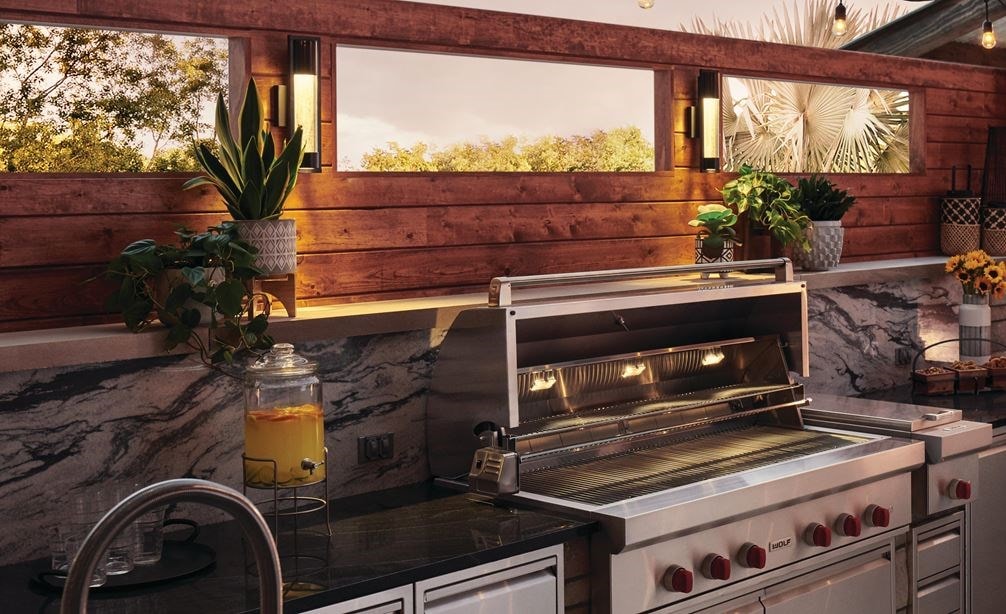 The Wolf 54&quot; Outdoor Gas Grill (OG54) shown blending seamlessly into a rich modern outdoor kitchen design offering pro quality amenities.