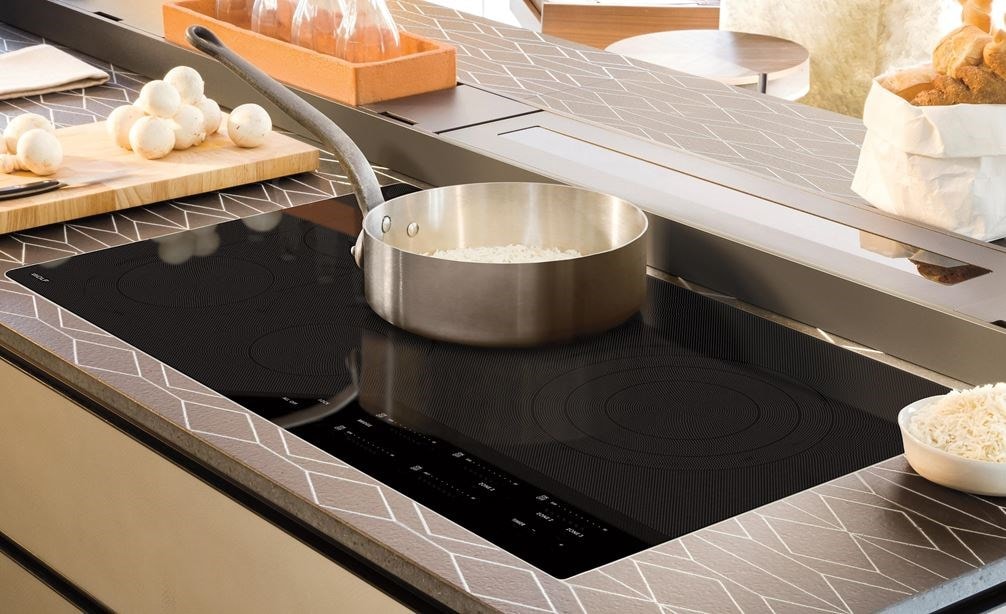Wolf 36&quot; Contemporary Electric Cooktop (CE365C/B) set flush in a luxury kitchen space with designer countertops and seamless cabinets