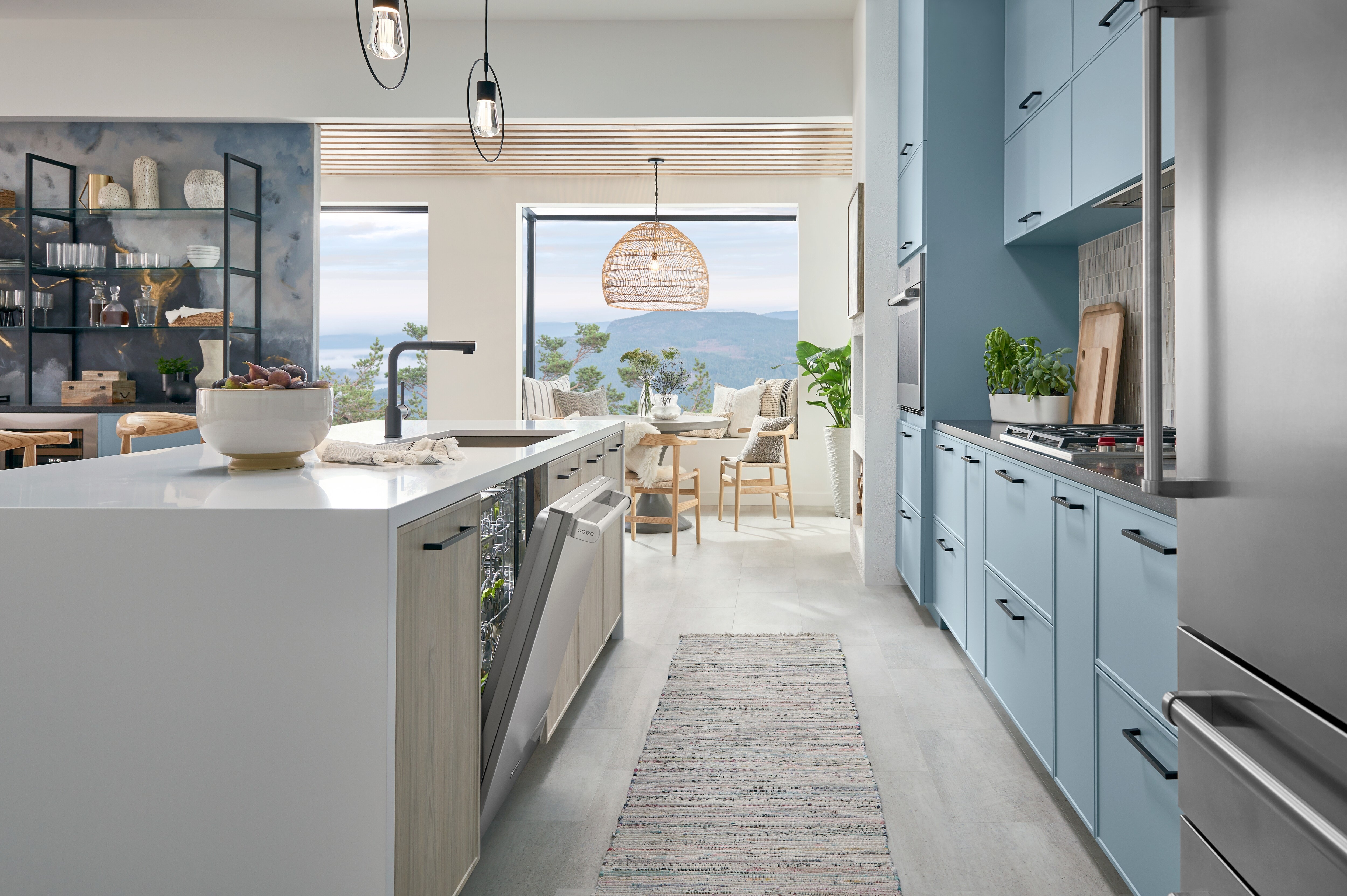 24 inch Stainless Steel Dishwasher by Cove Dishwashers shown with stainless steel door ajar in galley style kitchen featuring sky blue kitchen cabinets