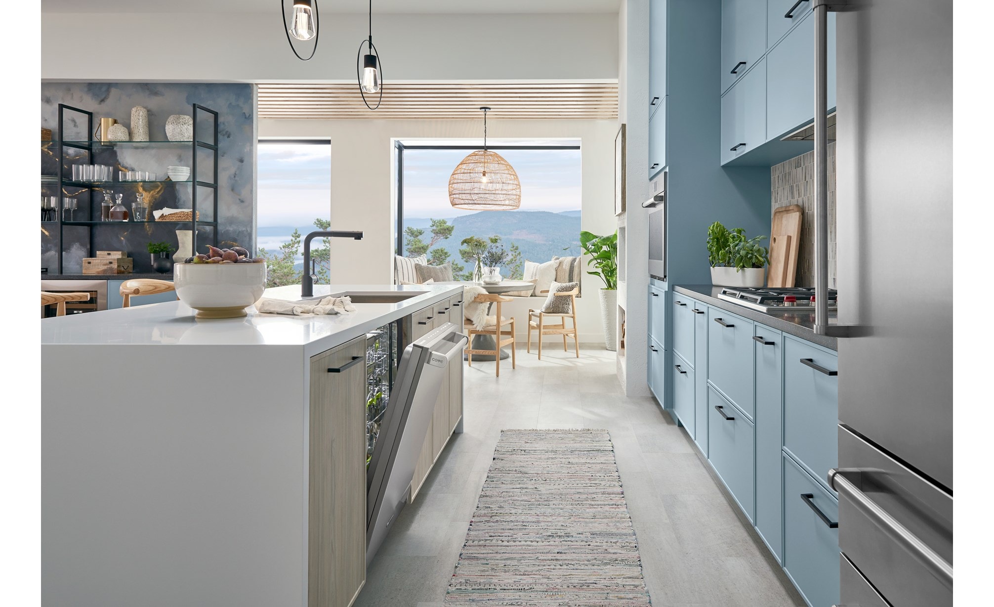 24 inch Stainless Steel Dishwasher by Cove Dishwashers shown with stainless steel door ajar in galley style kitchen featuring sky blue kitchen cabinets