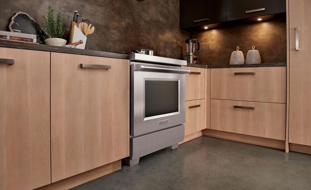 Wolf 30&#34; Professional Induction Range (IR30450/S/P) featured in light brown cabintry next to a Wolf Gourmet Blender.