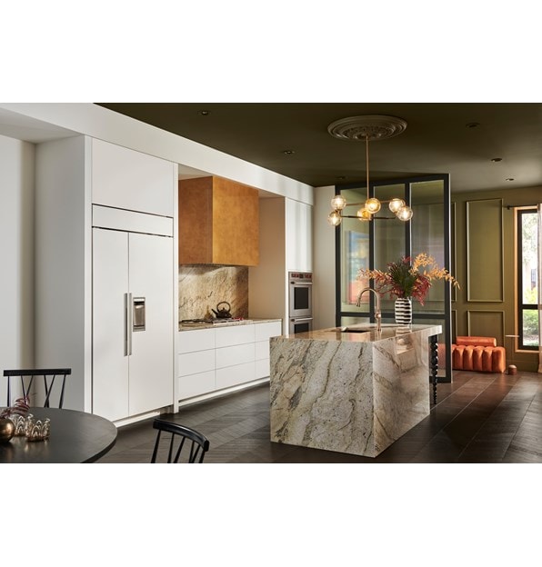 Panel Ready Sub-Zero 42 inch Classic Side-by-Side Refrigerator blends perfectly into white kitchen cabinetry in this modern and bold custom kitchen design featuring granite kitchen isalnd and matching backsplash