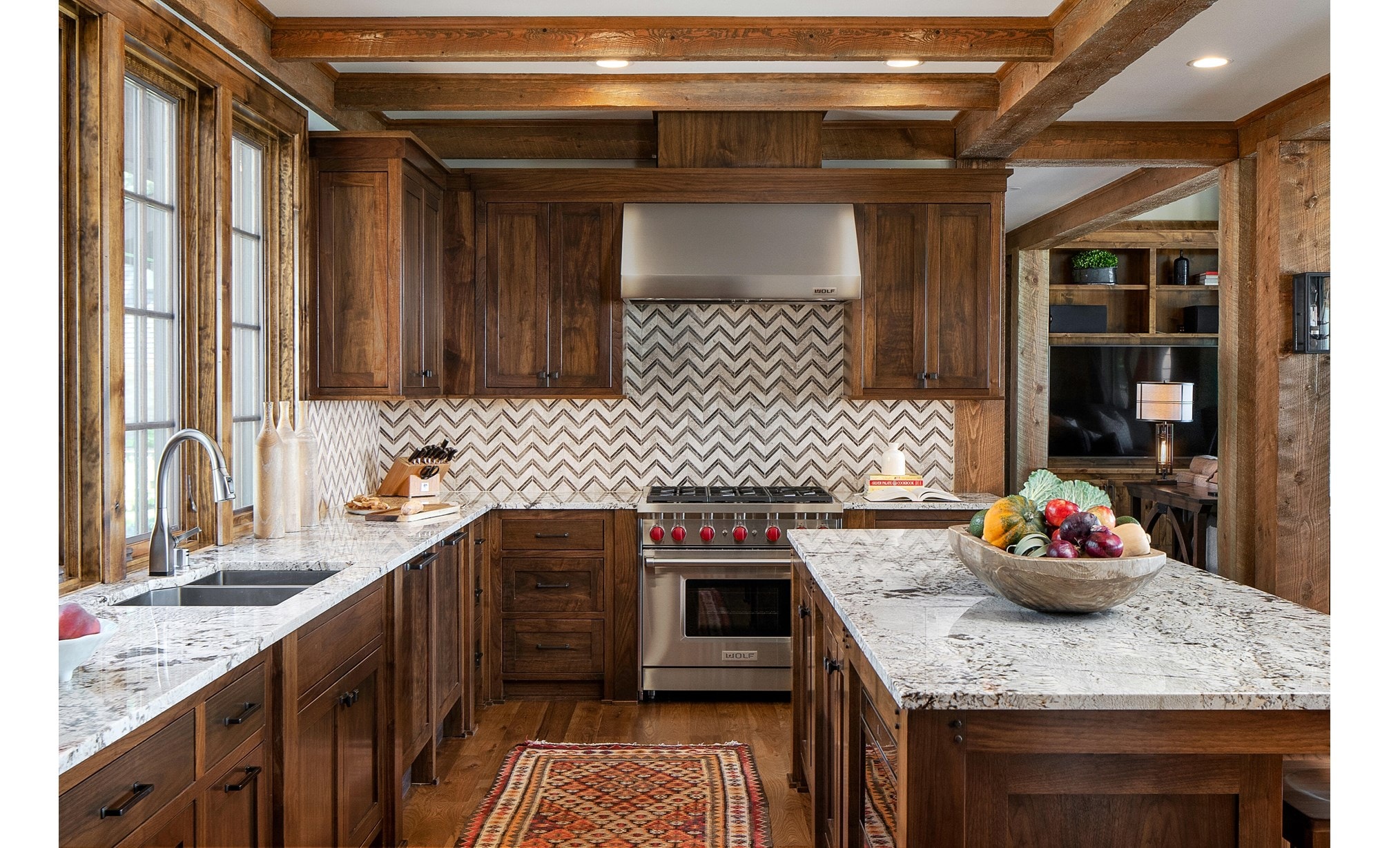 Wolf 36&34; Gas Range (GR366) and Wolf 36&34; Professional Wall Hood (PW362418) shown in custom kitchen design featuring warm wood cabinets, wood beams and wave patterned tile backsplash.