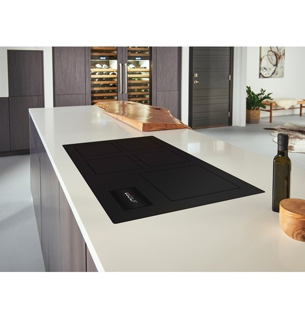 Wolf 36 Contemporary Induction Cooktop (CI36560C/B) featured in a modern kitchen design, blending seamlessly into smooth white countertops with warm wood tone cabinets.