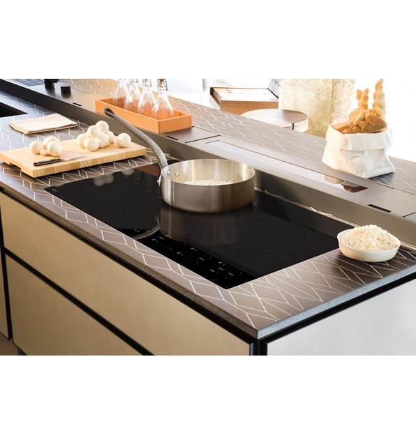 Wolf 36" Contemporary Electric Cooktop (CE365C/B) set flush in a luxury kitchen space with designer countertops and seamless cabinets