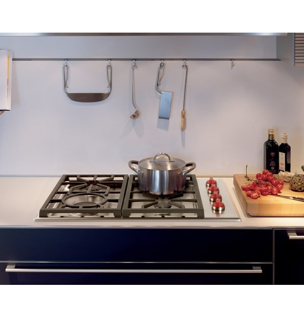 The Wolf 30" Professional Gas Cooktop 4 Burner (CG304P/S) featuring signature red knobs set with stainless steel utensil holder
