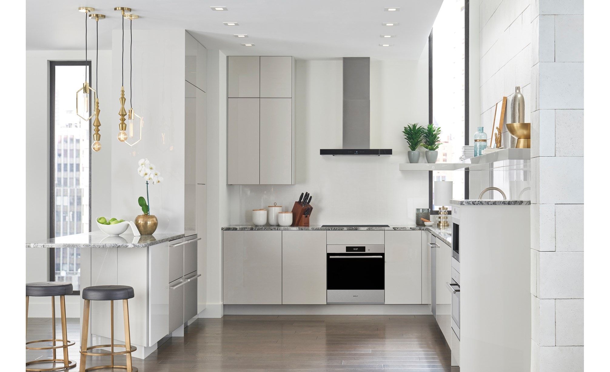 Wolf 30" Contemporary Induction Cooktop (CI30460C/B) shown here in a small space kitchen design featuring smooth white handleless cabinets and marble countertops