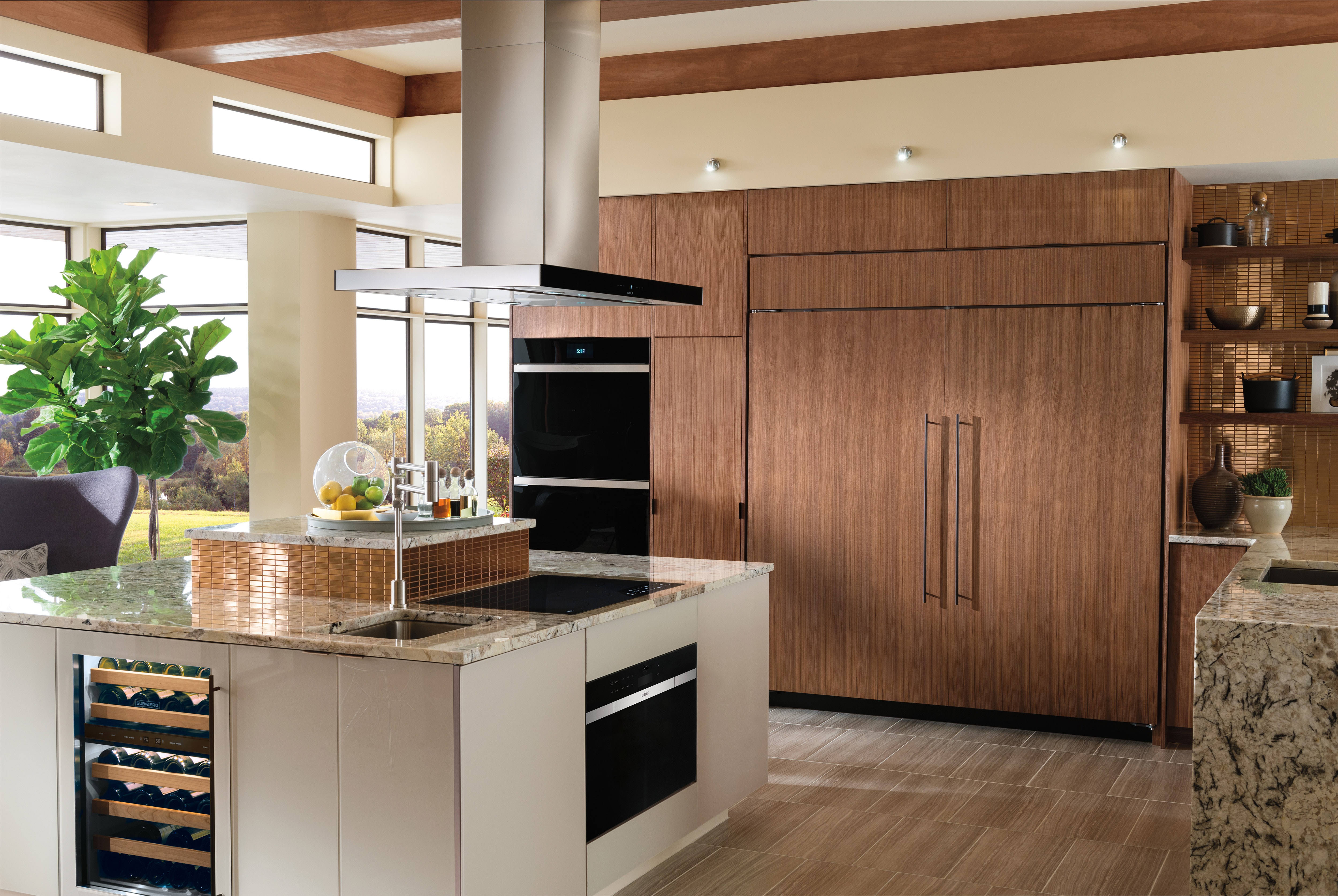 Wolf 30" Contemporary Induction Cooktop (CI304C/B) featured in large marble kitchen island with Wolf 42" Cooktop Island Hood (VI42B)