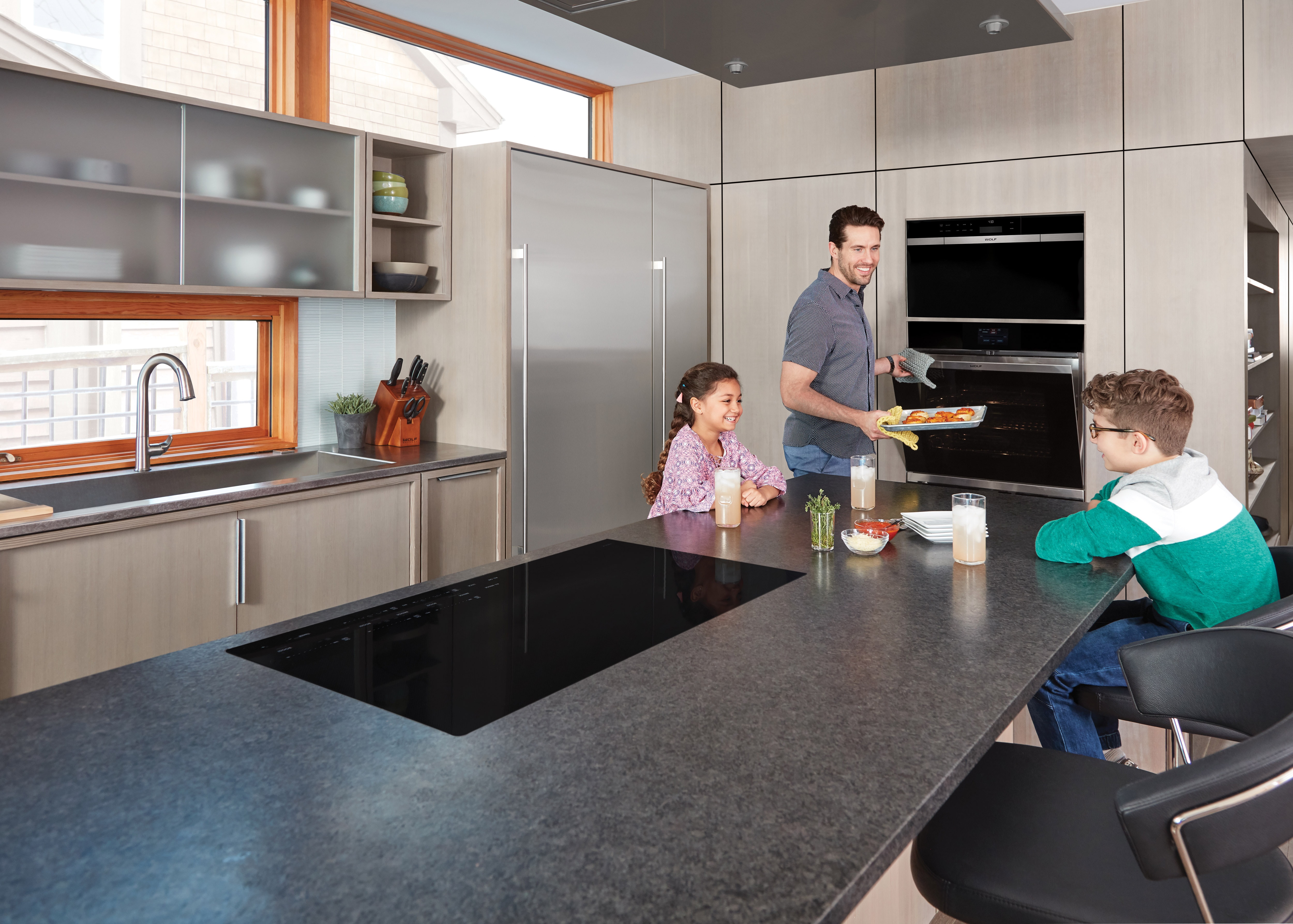 The Wolf 36" Contemporary Induction Cooktop (CI365C/B) shown in extra-large kitchen island bar is highly efficient and exceptionally safe