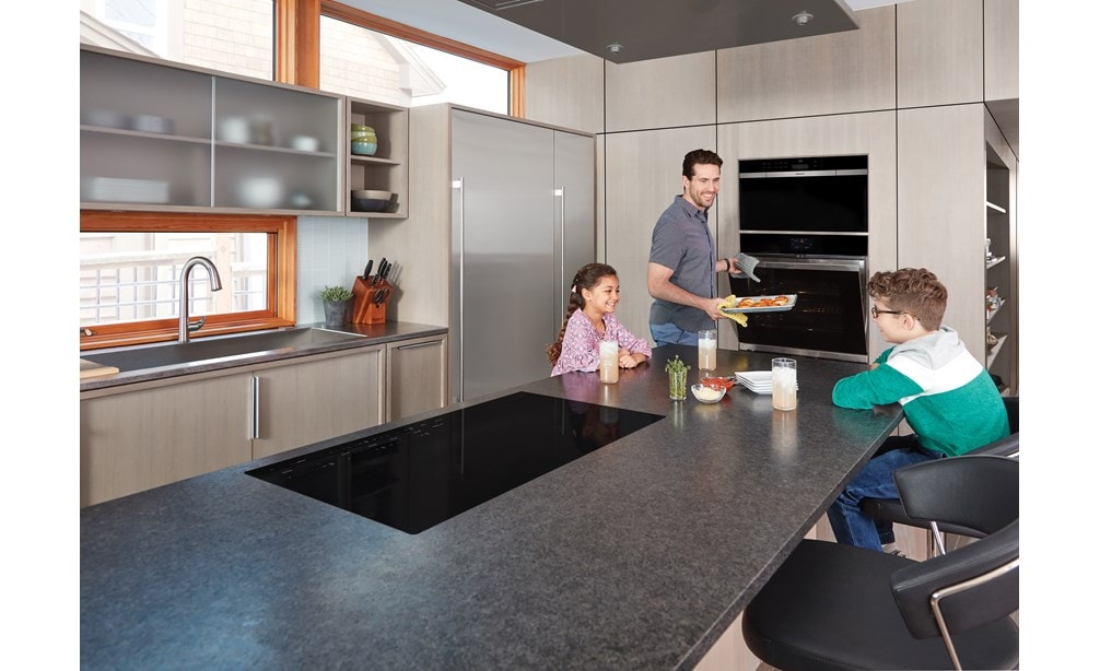 The Wolf 36" Contemporary Induction Cooktop (CI365C/B) shown in extra-large kitchen island bar is highly efficient and exceptionally safe