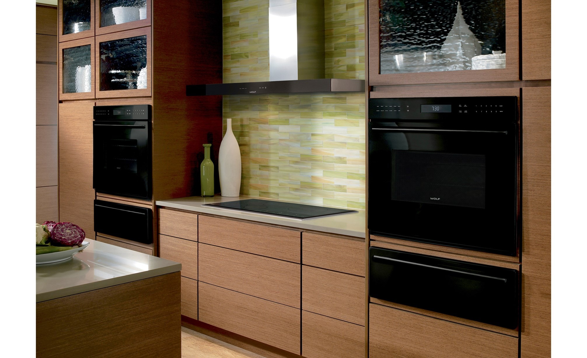 The Wolf 36" Transitional Induction Cooktop (CI365T/S) shown with a variety of Wolf cooking appliances in warm contemporary kitchen