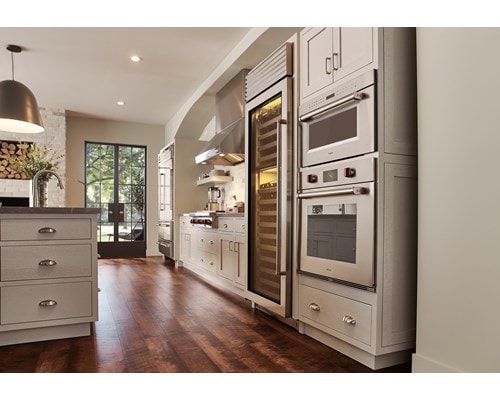 Wolf 30" M series Professional Drop-Down Door Microwave Oven (MDD30PM/S/PH) displayed in a classic medium tone wood floor kitchen design