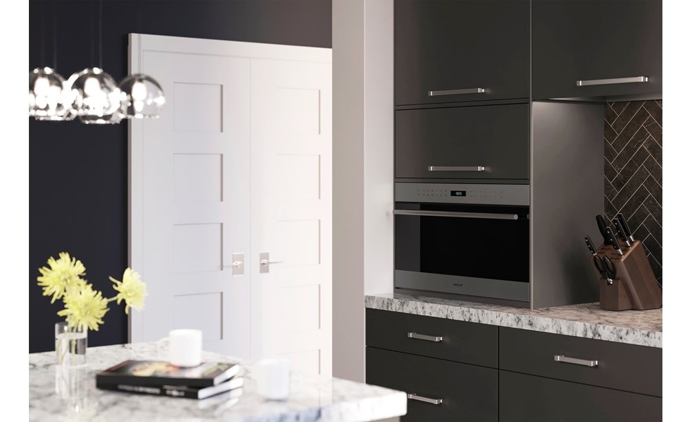 Wolf 30" E Series Transitional Drop-Down Door Microwave Oven (MDD30TE/S/TH) set expertly in smooth cabinetry against gray backsplash