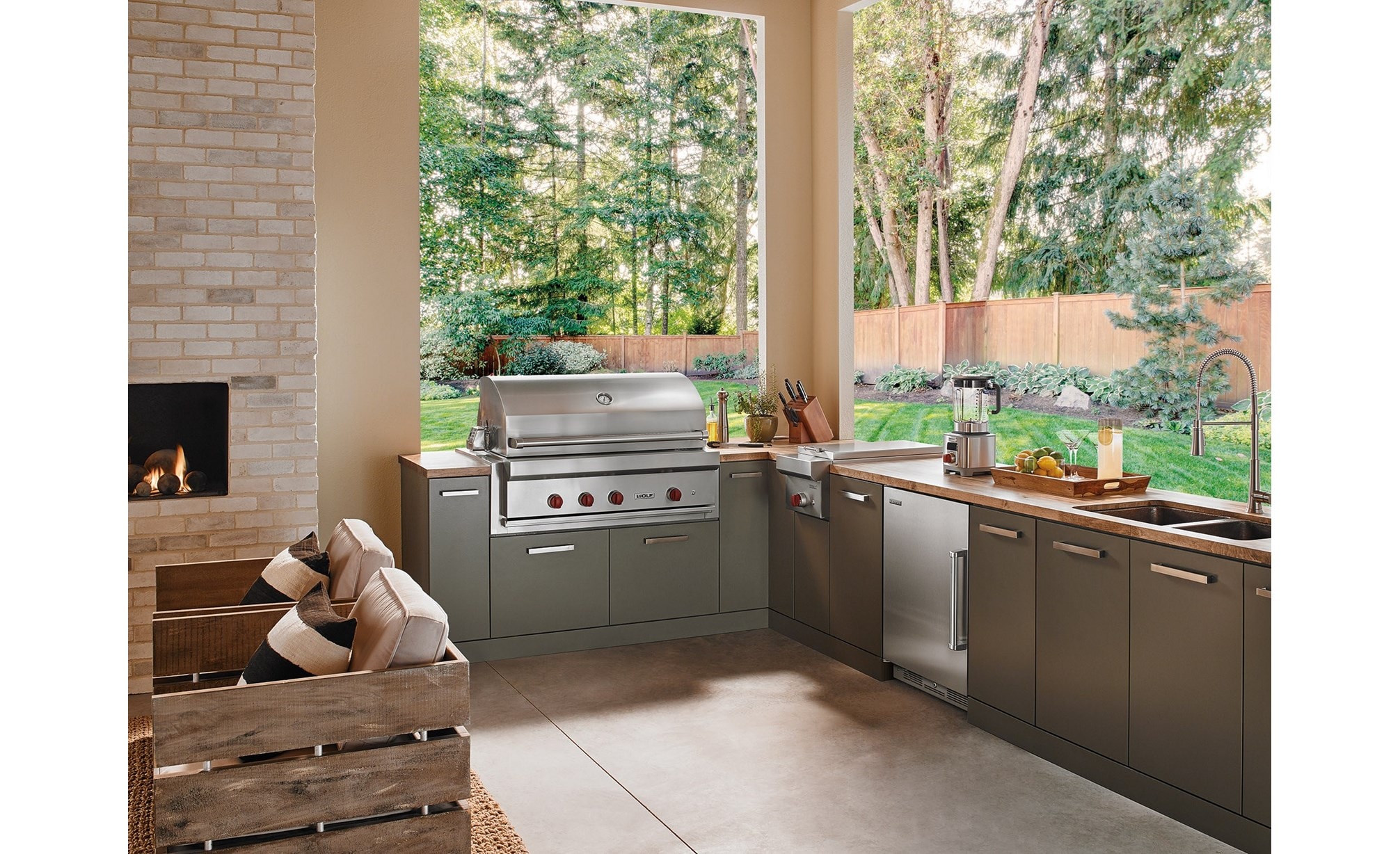 The Wolf 42" Outdoor Gas Grill (OG42) shown in a contemporary outdoor kitchen space offering comfort and professional kitchen amenities.