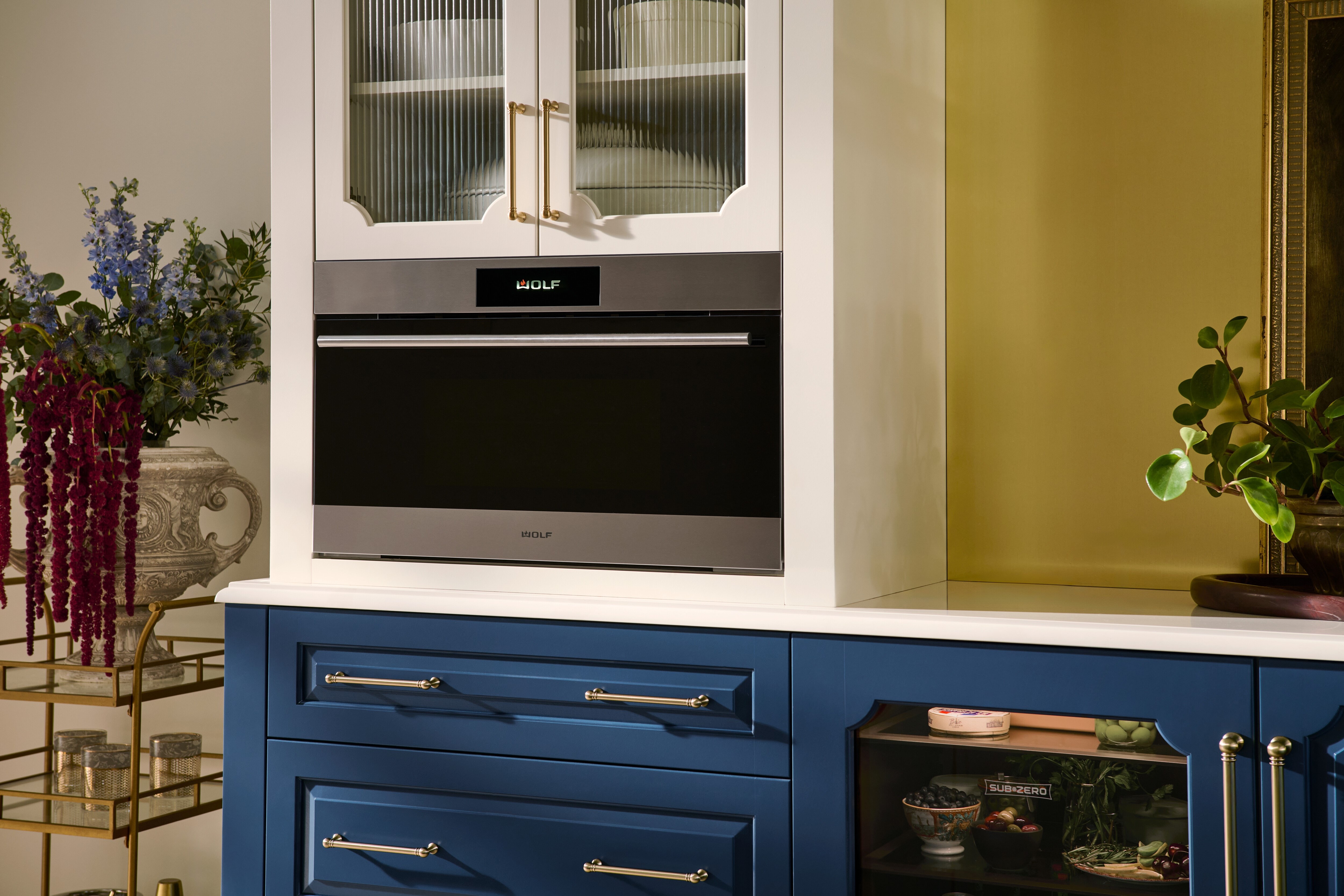 The Wolf 30" E Series Transitional Speed Oven - SPO3050TE/S/T in a modern blue and white kitchen