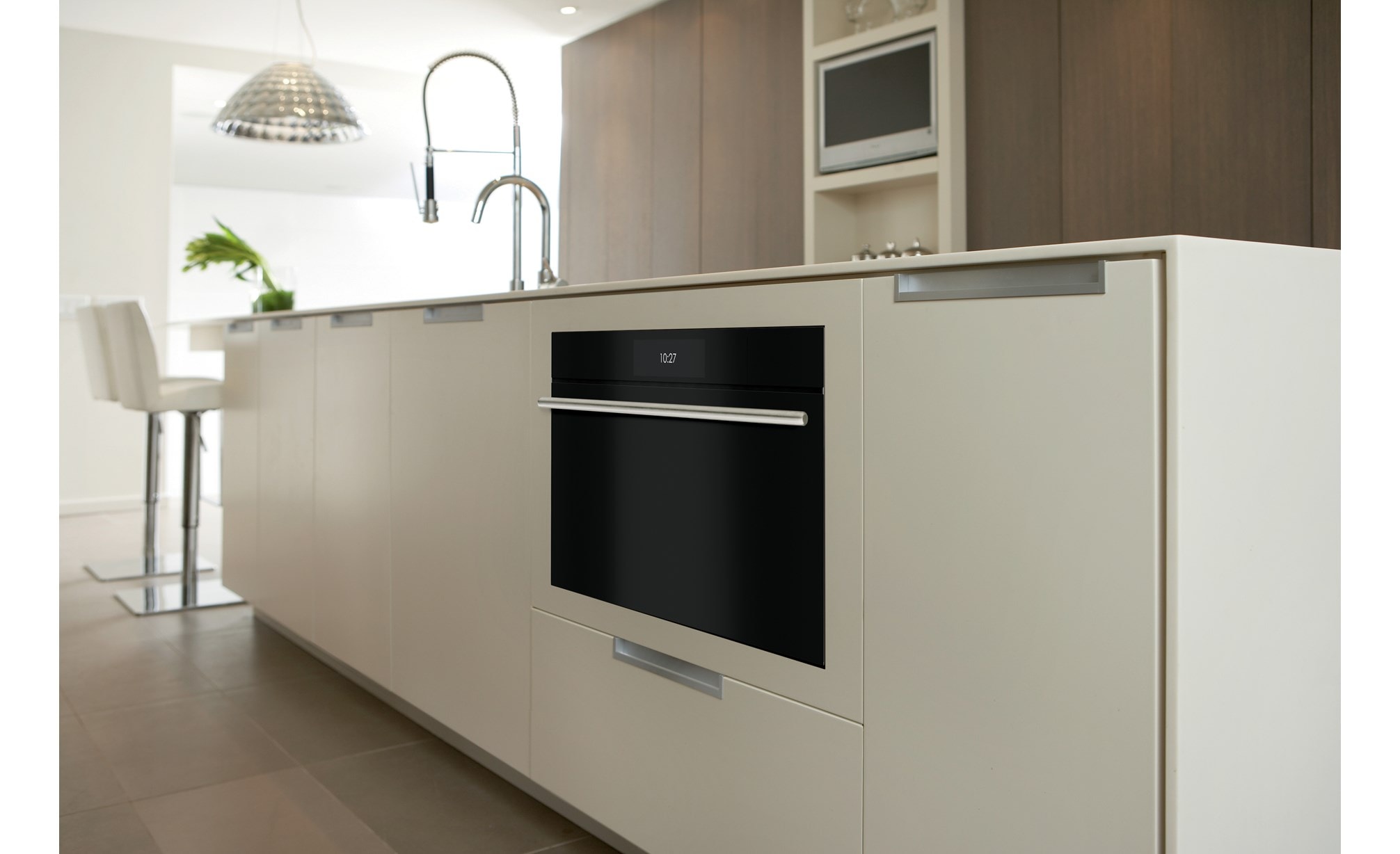 Closeup of undercounter Wolf 30" M Series Contemporary Convection Steam Oven (CSO3050CM/B/T) in a white kitchen island