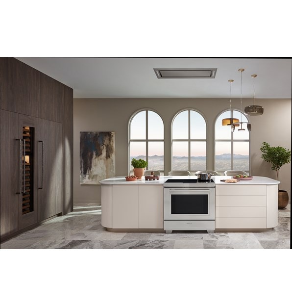 Wolf 30" Induction Range shown centered in front of arch windows in sleek custom kitchen island with pendant light above. 