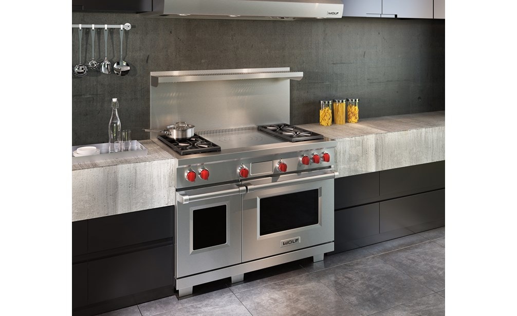 Wolf 48" Dual Fuel Range 4 Burner French Top (DF484F) shown with concrete and minimalist kitchen cabinets in an ultra-modern kitchen