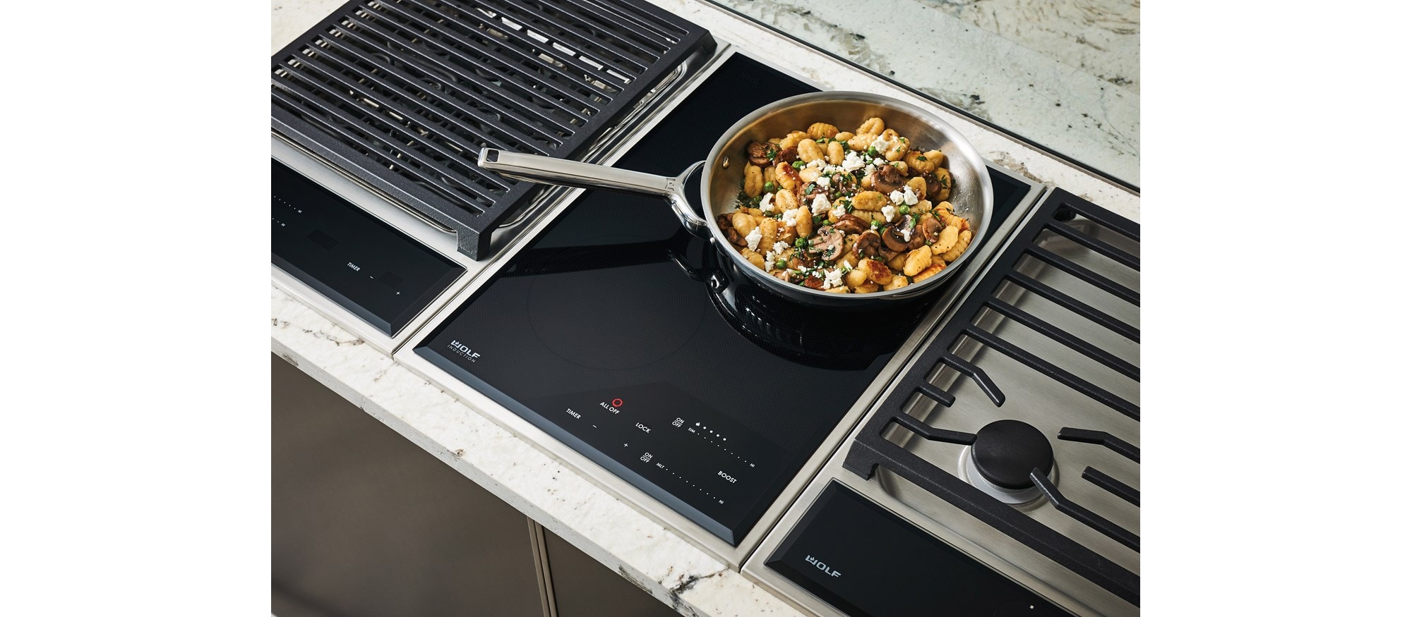 Wolf 15" transitional induction cooktop module (CI152TFS) paired with a 15" transitional grill module (GM15TFS) and 15" transitional gas cooktop module (CE152TFS)