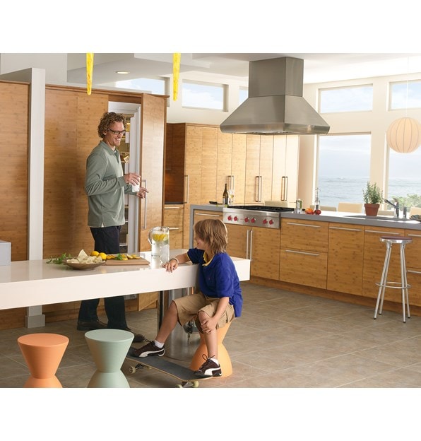 The Wolf 42" Pro Island Hood (PI423418) displayed in large open and bright contemporary kitchen featuring seamless wood grain cabinetry