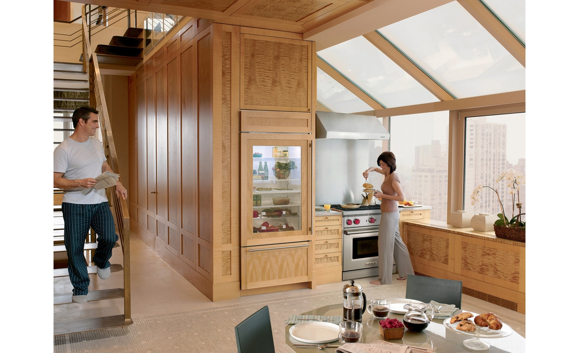 Wolf 30" Low Profile Wall Hood (PW302210) set in a custom kitchen design featuring high ceilings, large windows and natural wood cabinetry