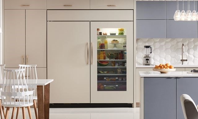 Elegant kitchen design featuring Sub-Zero Classic Series Refrigerator, Wolf Downdraft Ventilation, Wolf M Series Ovens and Module Cooktops all enclosed in custom panels