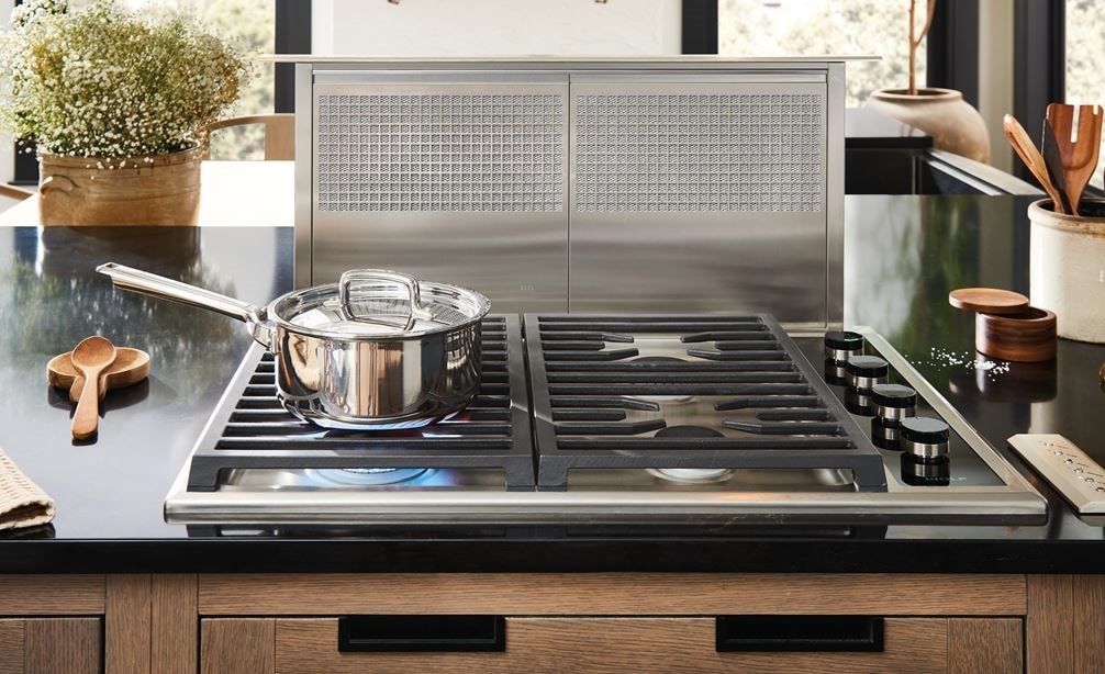 Wolf 30-inch gas cooktop with downdraft shown in a cottage kitchen design featuring warm wood tone cabinets.