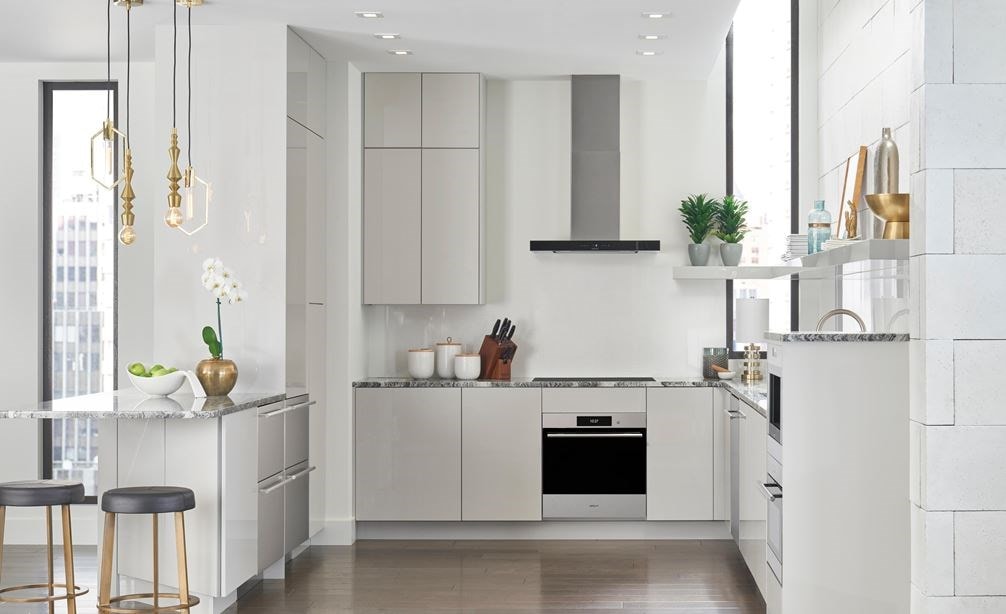 Wolf 30" Contemporary Induction Cooktop (CI30460C/B) shown here in a small space kitchen design featuring smooth white handleless cabinets and marble countertops