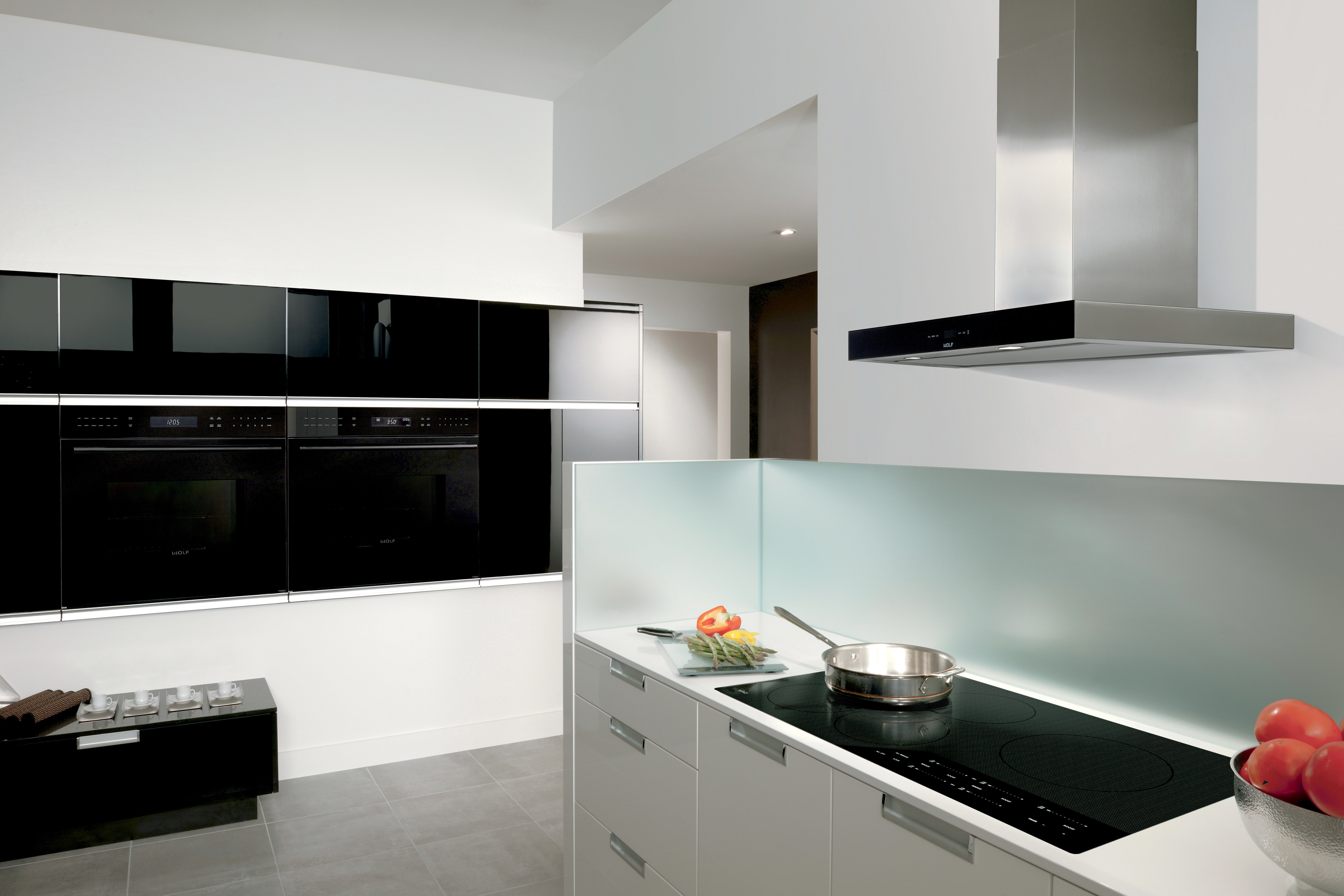 Wolf 36" Contemporary Induction Cooktop (CI365C/B) shown with 36" Cooktop Wall Hood Black (VW36B) shines in clean seamless kitchen design