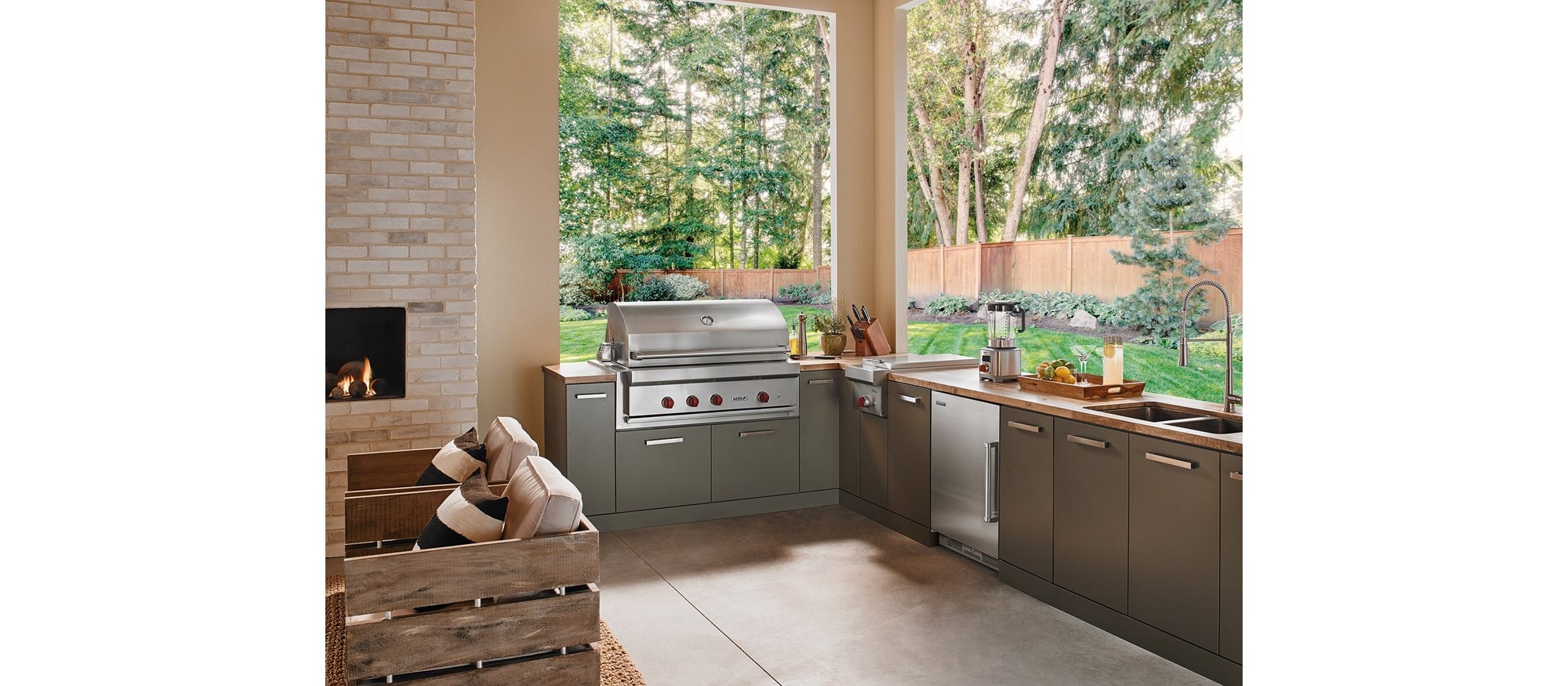 The Wolf 42" Outdoor Gas Grill (OG42) shown in a contemporary outdoor kitchen space offering comfort and professional kitchen amenities.