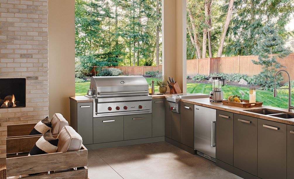 The Wolf 42" Outdoor Gas Grill (OG42) shown in a contemporary outdoor kitchen space offering comfort and professional kitchen amenities.