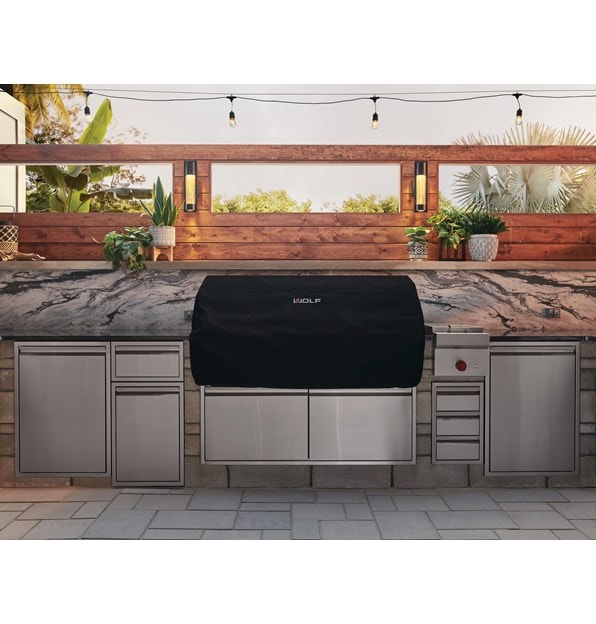 The Wolf 54" Outdoor Gas Grill (OG54) shown blending seamlessly into a rich modern outdoor kitchen design offering pro quality amenities. 