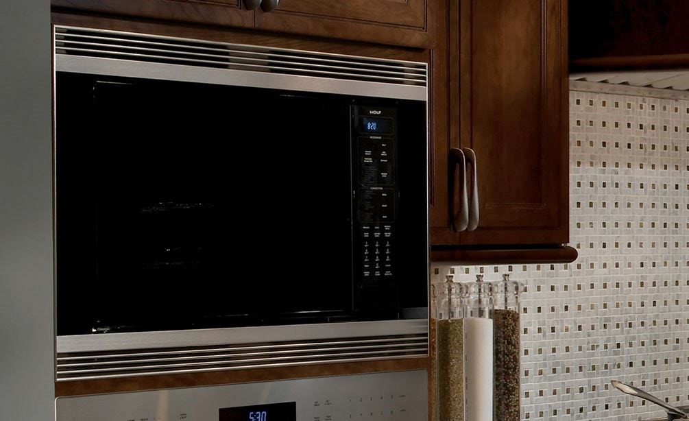 The Wolf 24&quot; Convection Microwave Oven (MC24) sleek black design adds depth to this kitchen featuring stainless steel Wolf appliances