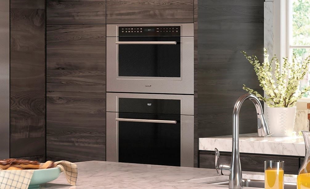 Wolf 30&quot; M Series Transitional Drop-Down Door Microwave Oven (MDD30TM/S/TH) framed in large wood panel cabinetry in contemporary kitchen
