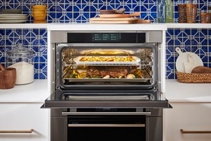 Wolf Convection Steam Oven displayed in a Mediterranean style kitchen design featuring blue tile backsplash and open kitchen shelves.
