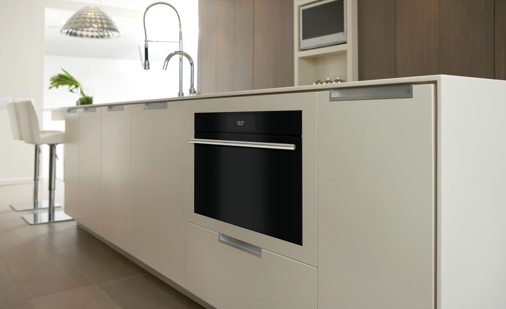 Closeup of undercounter Wolf 30&quot; M Series Contemporary Convection Steam Oven (CSO3050CM/B/T) in a white kitchen island
