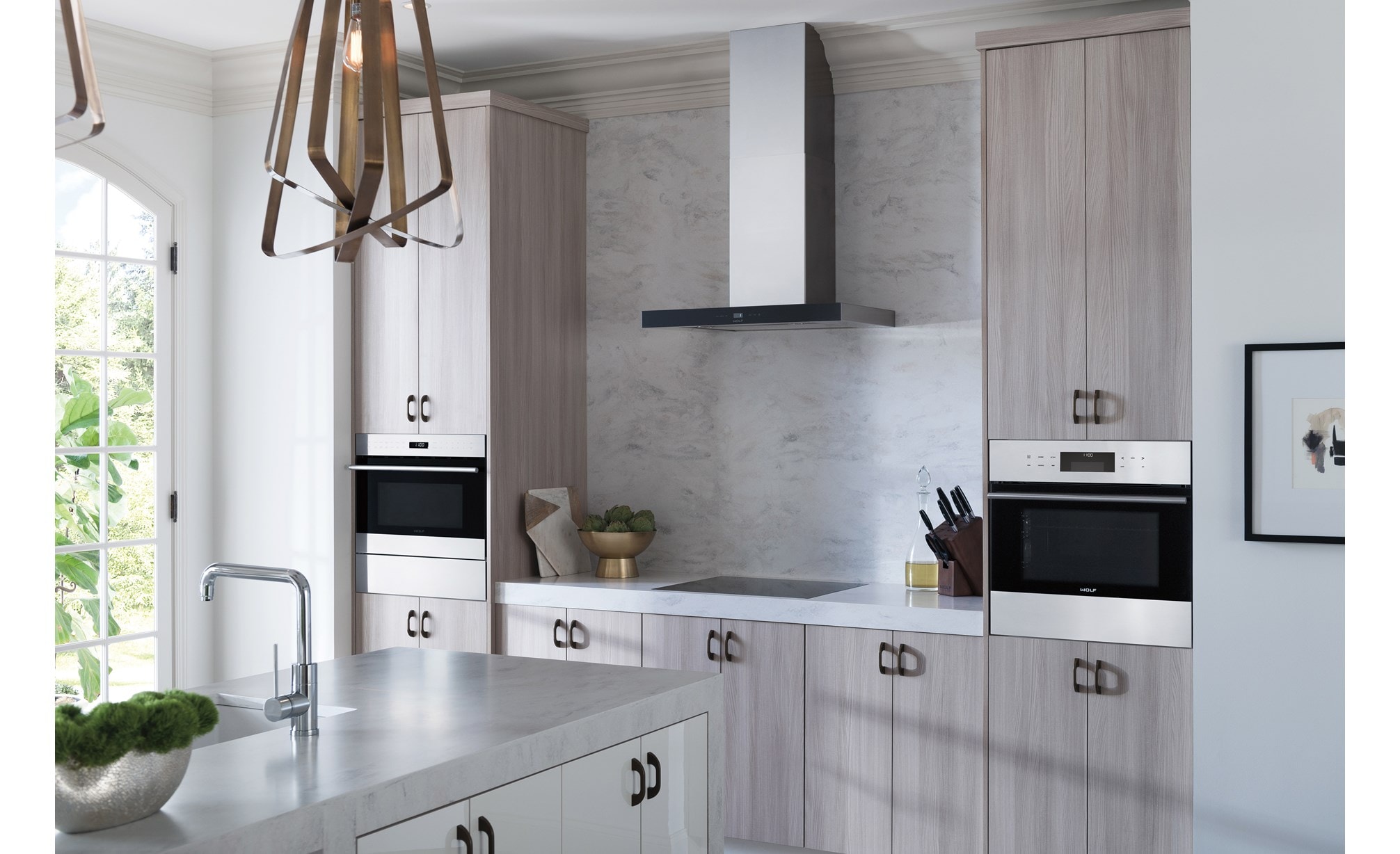 The Wolf 30" Cooktop Wall Hood - Black (VW30B) with Wolf 24" Contemporary Induction Cooktop (CI243C/B) shown in a bright airy kitchen