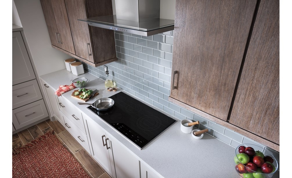 The Wolf 36" Cooktop Wall Hood - Glass (VW36G) featured in a cozy kitchen design with warm wood cabinets and tile backsplash