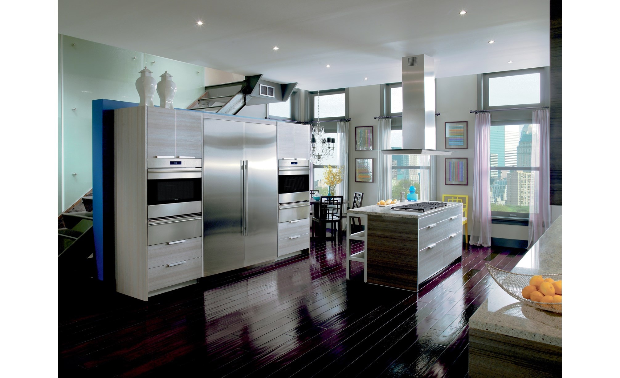 The Wolf 45" Cooktop Island Hood (VI45G) displayed in a large open modern kitchen featuring glossy wood flooring