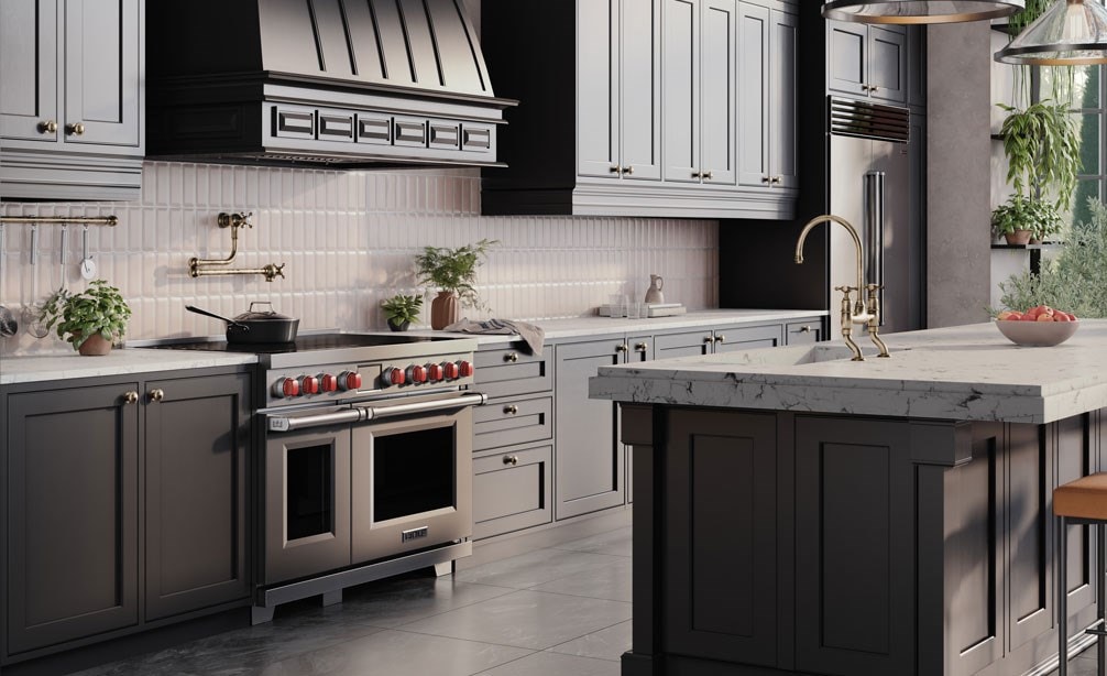 Wolf Professional Induction Range with stainless accent oven door and iconic red knobs shown in a modern bohemian kitchen design featuring custom grey kitchen cabinets enclosing a Wolf Pro Hood Liner.