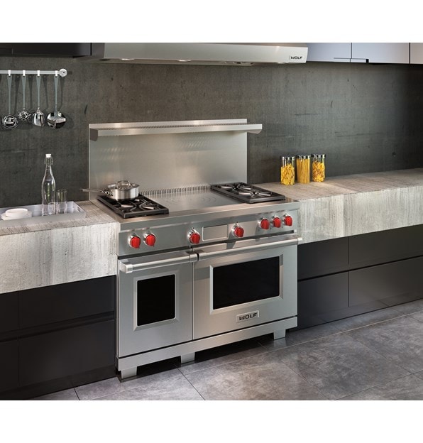 Wolf 48" Dual Fuel Range 4 Burner French Top (DF484F) shown with concrete and minimalist kitchen cabinets in an ultra-modern kitchen
