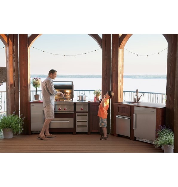 The Wolf 30" Outdoor Warming Drawer (WWD30O) shown in a gourmet outdoor cooking area featuring best-in-class Wolf cooking appliances